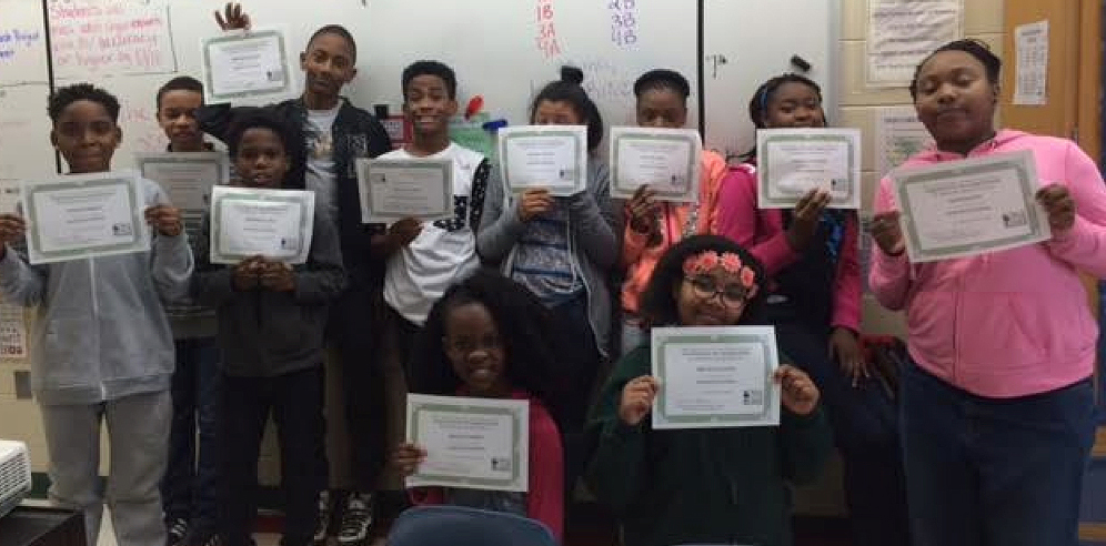 Boys and girls proudly showing their certificates